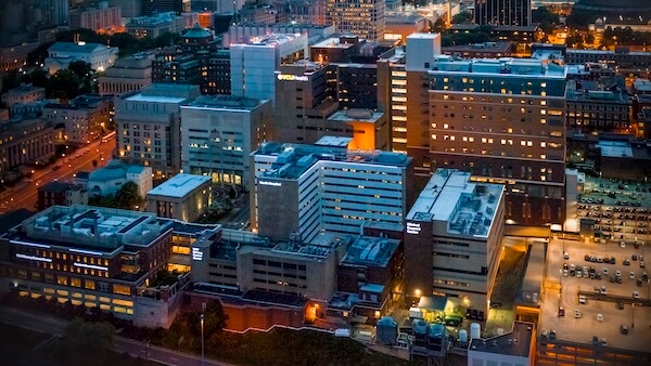 A nighttime aerial perspective of VCU Health’s extensive hospital campus, with the cityscape of Richmond in the background.